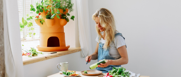 Femme qui épluche ses légumes pour le composteurs